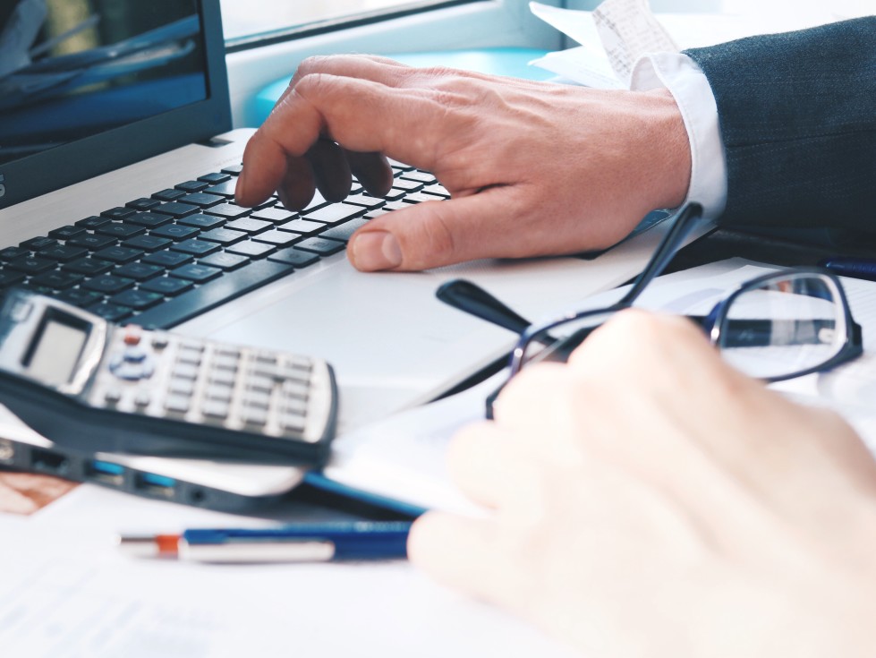 sonegação fiscal - homem em uma mesa digitando em um notebook